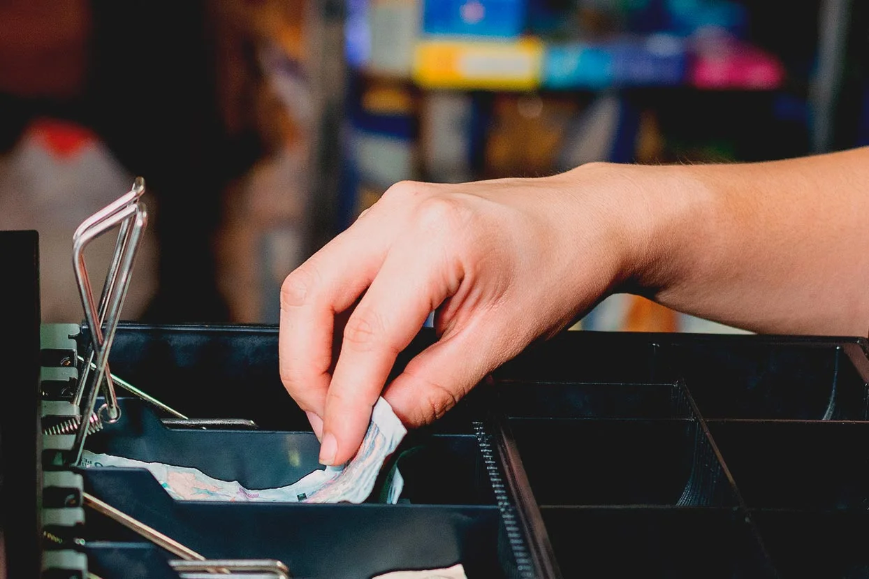 Dinero del negocio en una caja registradora.